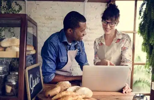 Boston Business Owners at a Bakery in front of a computer working on AI plan for their business